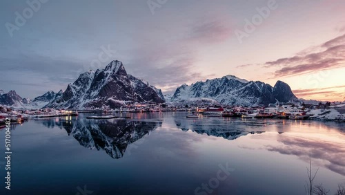 Traditional fishing village in scandinavian on coastline with mountain range reflection on arctic ocean in the morning on winter at Reine town, Lofoten Islands, Norway