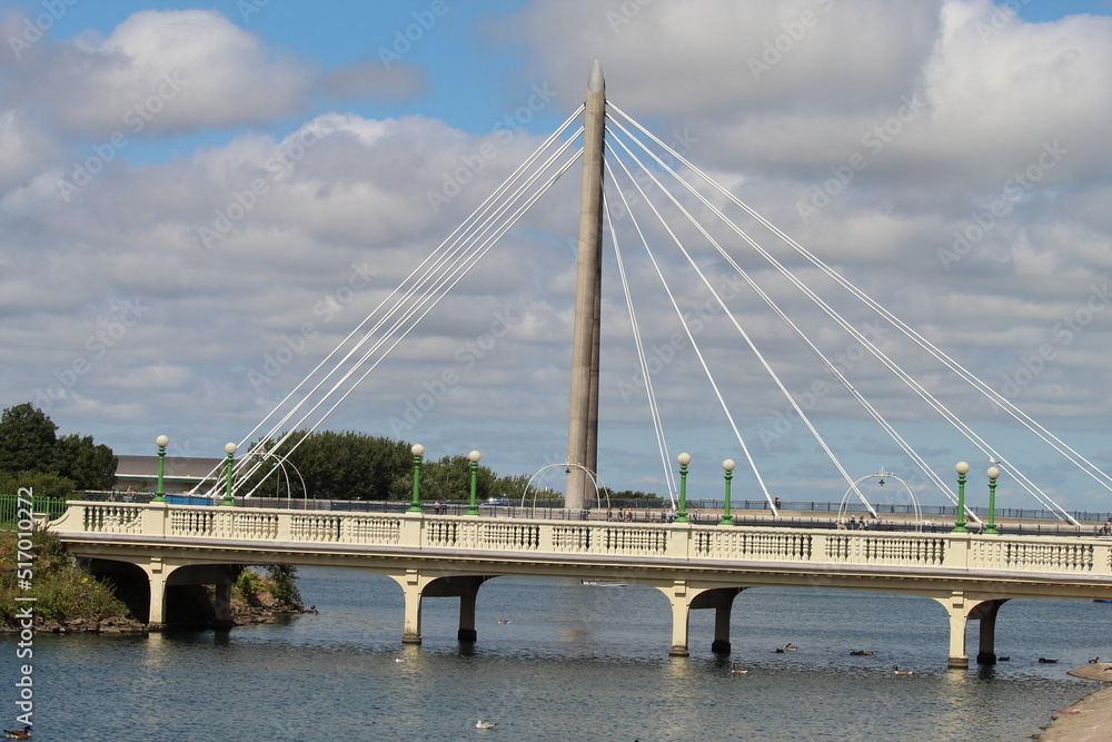 Fototapeta premium The bridge over the lake in Southport. This bridge connects the beach and shore to the main town. This photo was taken on a very warm and sunny day.