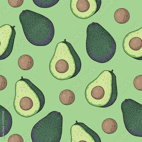 Seamless pattern with cut avocados on light green background. Ripe half of avocado hass with pit photo