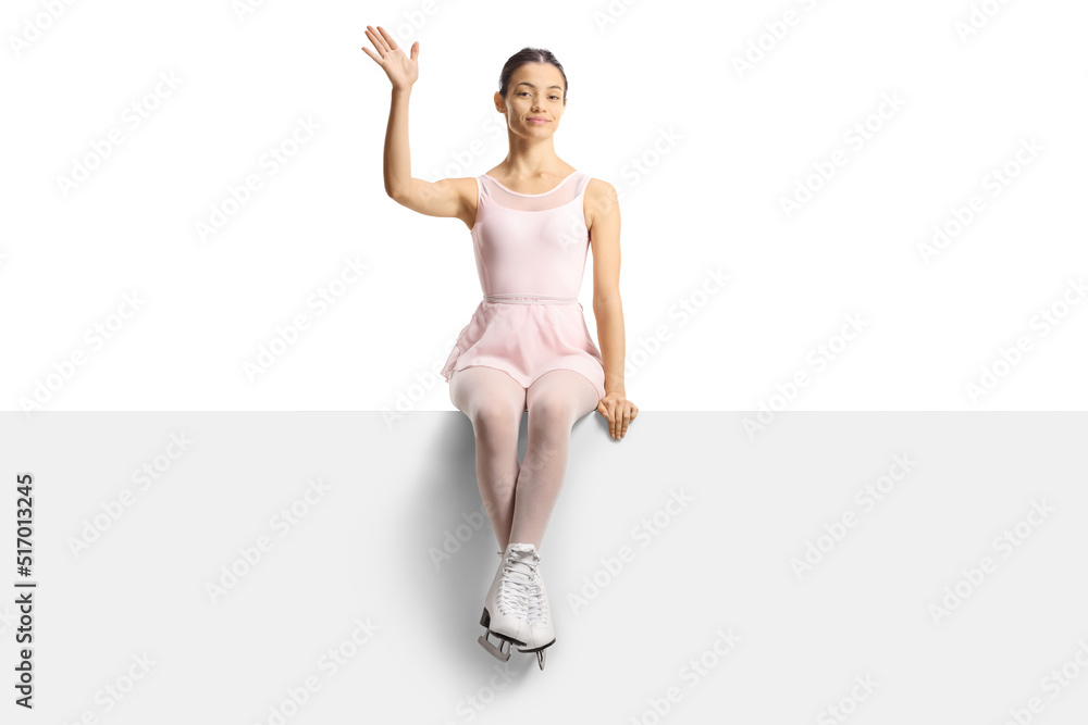 Beautiful female figure skater sitting on a blank panel and waving