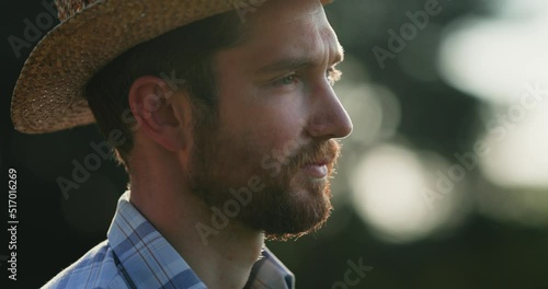 Portrait of serious male farmer looking away and admiring rural landscape