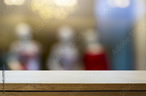 Art Empty wooden deck table over blurred fashion boutique background.