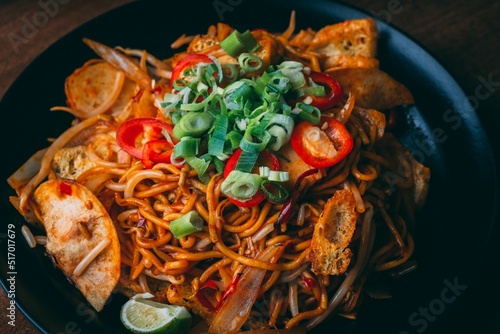 Tasty Kung pao noodles with crusty bread, pepper and greens photo