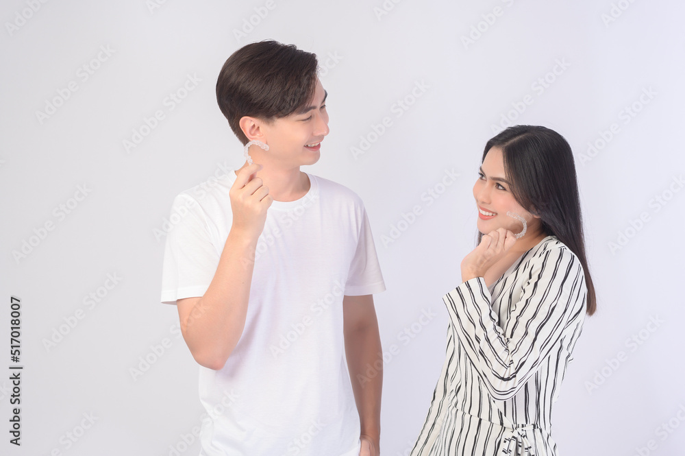 Young smiling man amd woman holding invisalign braces over white background studio, dental healthcare and Orthodontic concept.. Young smiling man amd woman holding invisalign braces over white background studio, dental healthcare and Orthodontic concept..