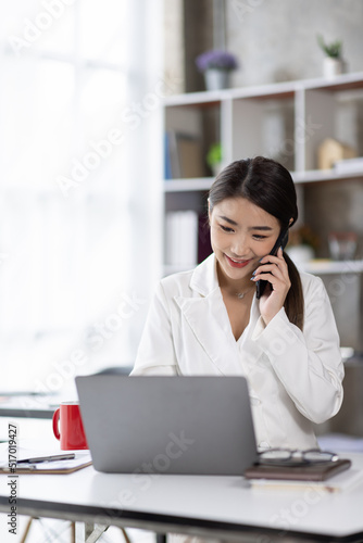 Businessman talking on smartphone and working in office. Asian female Business sitting at his workplace.