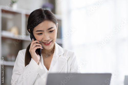 Businessman talking on smartphone and working in office. Asian female Business sitting at his workplace.