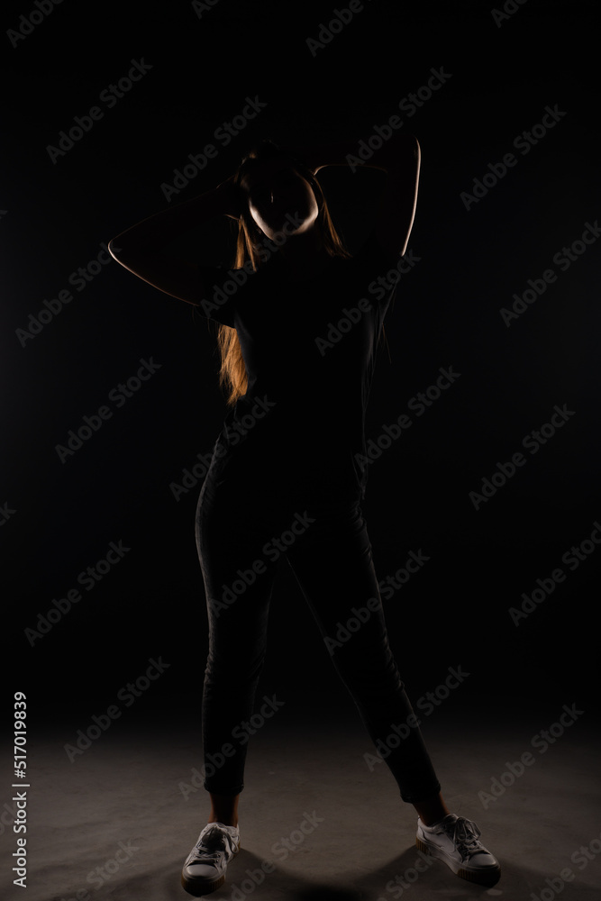 Silhouette of a girl posing with her hands