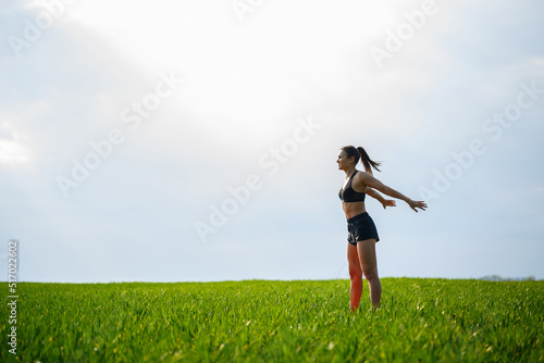 Attractive girl athlete does warm-up outdoors  exercises for muscles