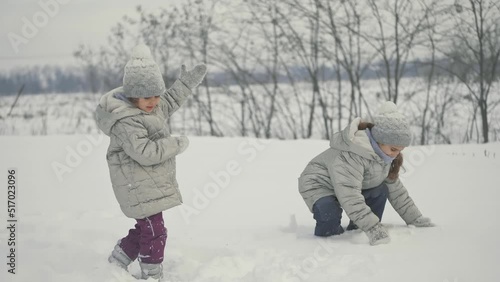 Happy children play snowballs, run, throw snow. Funny kids play games indoors in the winter with snow