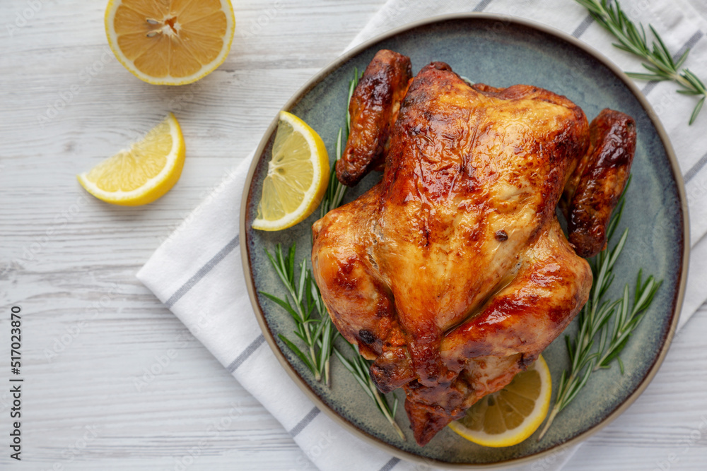 Homemade Lemon and Herb Rotisserie Chicken on a Plate, top view. Flat lay, overhead, from above. Homemade Lemon and Herb Rotisserie Chicken on a Plate, top view. Flat lay, overhead, from above.