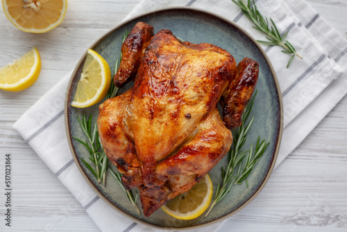 Homemade Lemon and Herb Rotisserie Chicken on a Plate, top view. Flat lay, overhead, from above. Close-up.