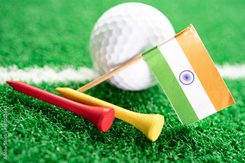 Golf ball with India flag and tee on green lawn or grass is most