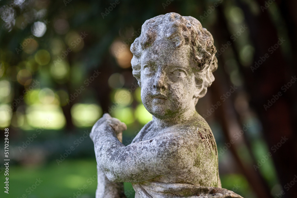 stone statue corroded by time in a romantic garden of an ancient palace in Mantua
