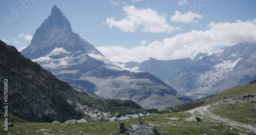 People walking on mountainside landscape surrounding the Matterhorn in Switzerland photo