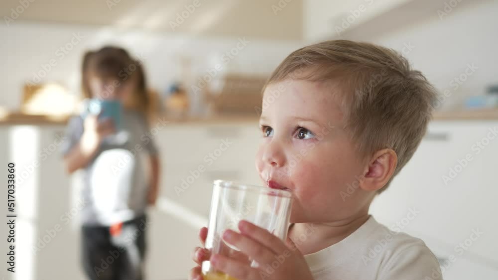 children drinking juice. happy family a healthy eating kid dream concept. daughter son drinking yellow juice from a glass cup in kitchen indoor. child drinking fruit juice. Young team drinking juice children drinking juice. happy family a healthy eating kid dream concept. daughter son drinking yellow juice from a glass cup in kitchen indoor. child drinking fruit juice. Young team drinking juice