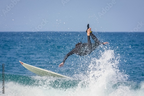 Foto Surfer riding a point break waves and being wipeout in Jeffreys Bay, South Afric