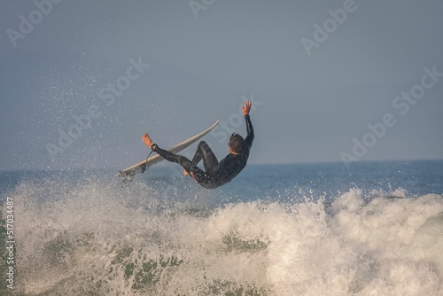 Surfer riding a point break waves and being wipeout in Jeffreys Bay, South Africa