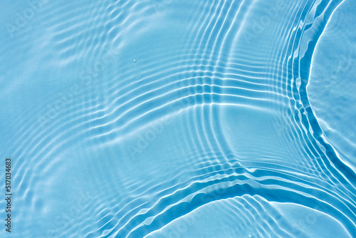 Background, texture of transparent blue water with ripples and waves