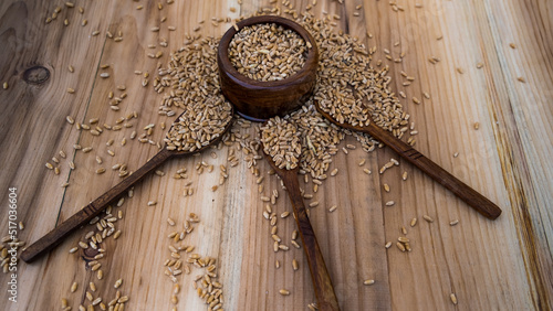 Wooden utensil. Wooden pots. Wheat in wooden bowl and spoon. Wooden utensils with natural background. utensils. spoon. bowl. wheat. vintage. flat lay.	