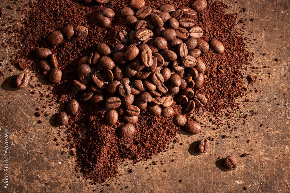 Roasted coffee beans different sort ground and whole isolated close up on brown grunge background Roasted coffee beans different sort ground and whole isolated close up on brown grunge background