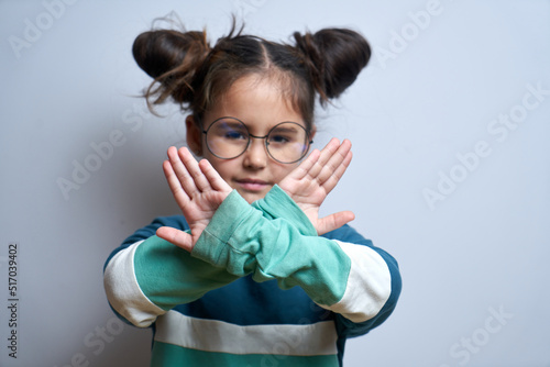 Say no to child abuse. Little girl showing stop gesture isolated on white background