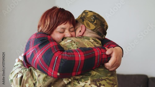 Veteran soldier greeting and hugging his wife reunited after US army service - Family concept photo