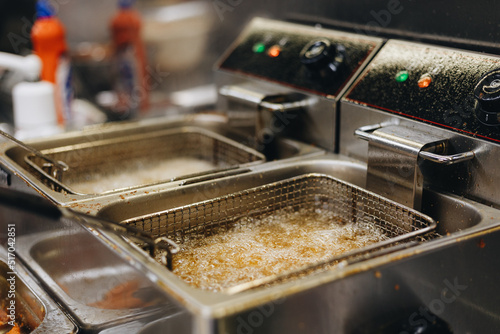 Frying chicken nuggets in deep fryer. Restaurant meal preparation