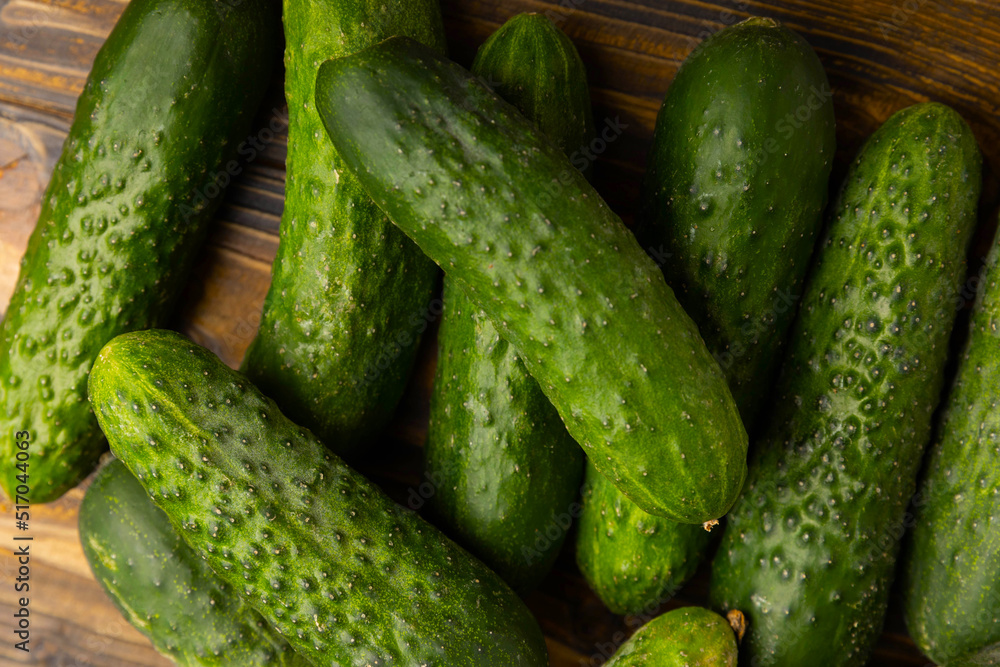 Fresh organic cucumbers on a brown wooden table. Salad ingredient. Fresh vegetables. Vegan food. Healthy food. Fresh organic vegetables. Fresh organic cucumbers on a brown wooden table. Salad ingredient. Fresh vegetables. Vegan food. Healthy food. Fresh organic vegetables.