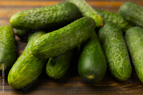 Fresh organic cucumbers on a brown wooden table. Salad ingredient. Fresh vegetables. Vegan food. Healthy food. Fresh organic vegetables.