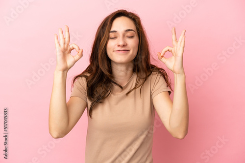 Young caucasian woman isolated on pink background in zen pose