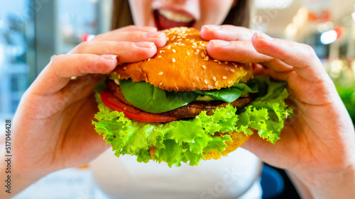 Vegan burger healthy vegetarian hamburger. Salad, avocado, vegetable on veggie sandwich eating cute woman. Vegetarian hamburger healthy diet food.