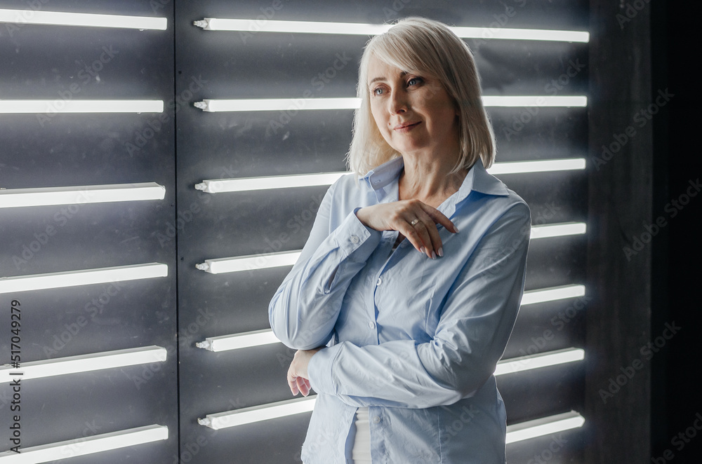 Fototapeta premium a woman in a blue shirt near a wall with backlight
