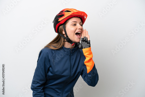 Young cyclist Lithuanian woman isolated on white background shouting with mouth wide open to the side