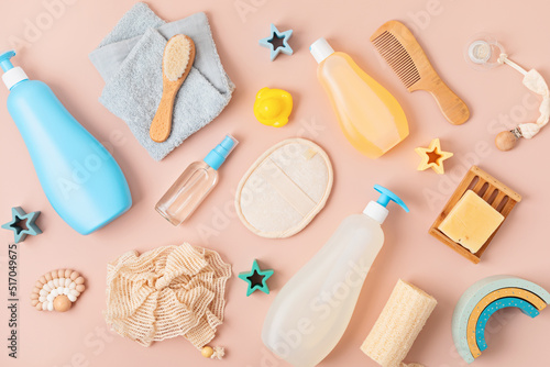Set of baby toiletries, child organic hygiene and bath accessories, shower gel, shampoo, essential oil, towel on pink pastel background. Top view, flatlay
