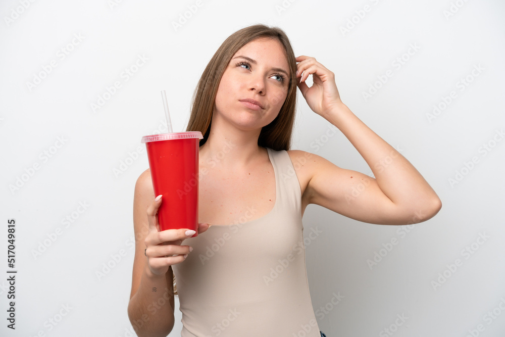 Young Lithuanian woman holding refreshment isolated on white background having doubts and with confuse face expression Young Lithuanian woman holding refreshment isolated on white background having doubts and with confuse face expression