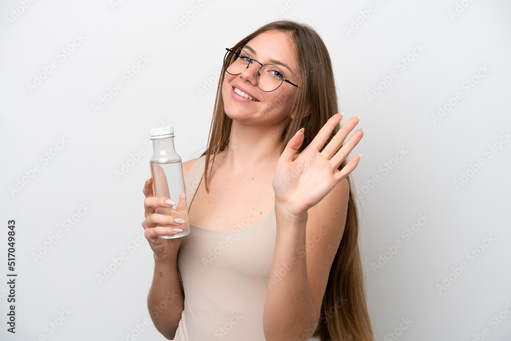 Young Lithuanian woman with a bottle of water isolated on white background saluting with hand with happy expression Young Lithuanian woman with a bottle of water isolated on white background saluting with hand with happy expression