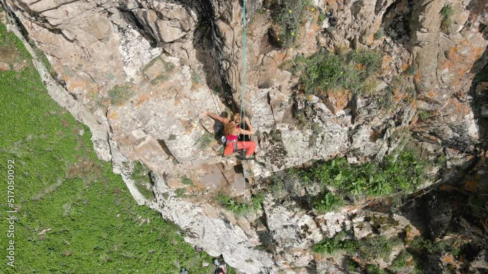 Woman athlette climbing on the high rock in the mountains Woman athlette climbing on the high rock in the mountains