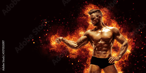 Brutal strong athletic Bodybuilder posing. Fire and spark explosion in the background.