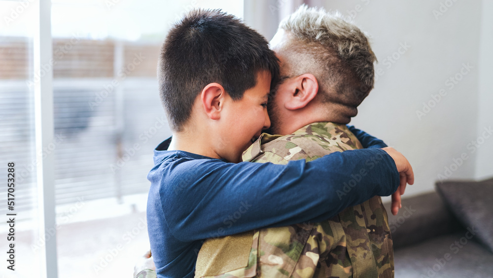 Veteran soldier greeting and hugging his son reunited after US army service - Family concept Veteran soldier greeting and hugging his son reunited after US army service - Family concept