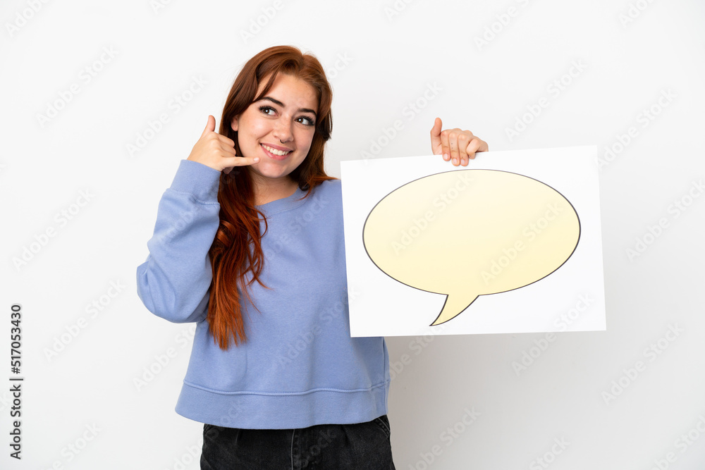 Young redhead woman isolated on white background holding a placard with speech bubble icon and doing phone gesture Young redhead woman isolated on white background holding a placard with speech bubble icon and doing phone gesture