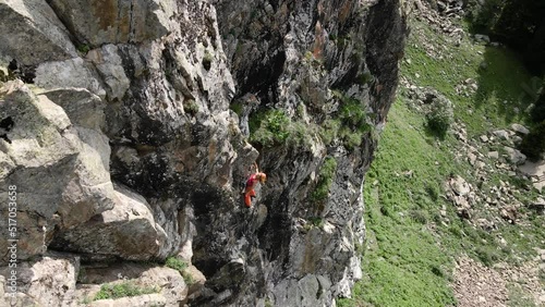 Woman athlette climbing on the high rock in the mountains photo