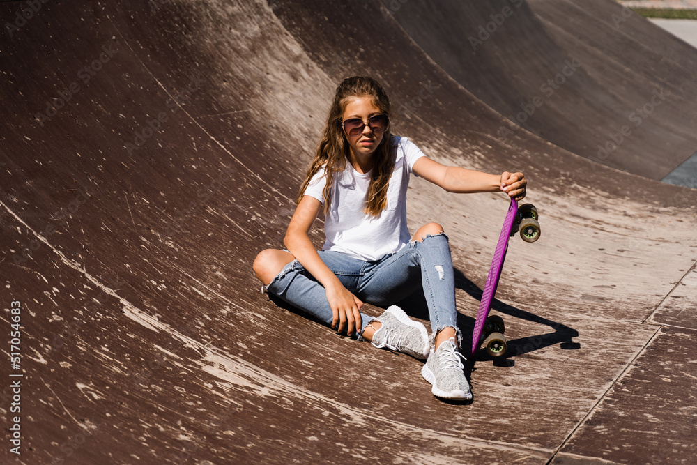 foto-de-child-model-in-glasses-sitting-and-posing-with-penny-board-on