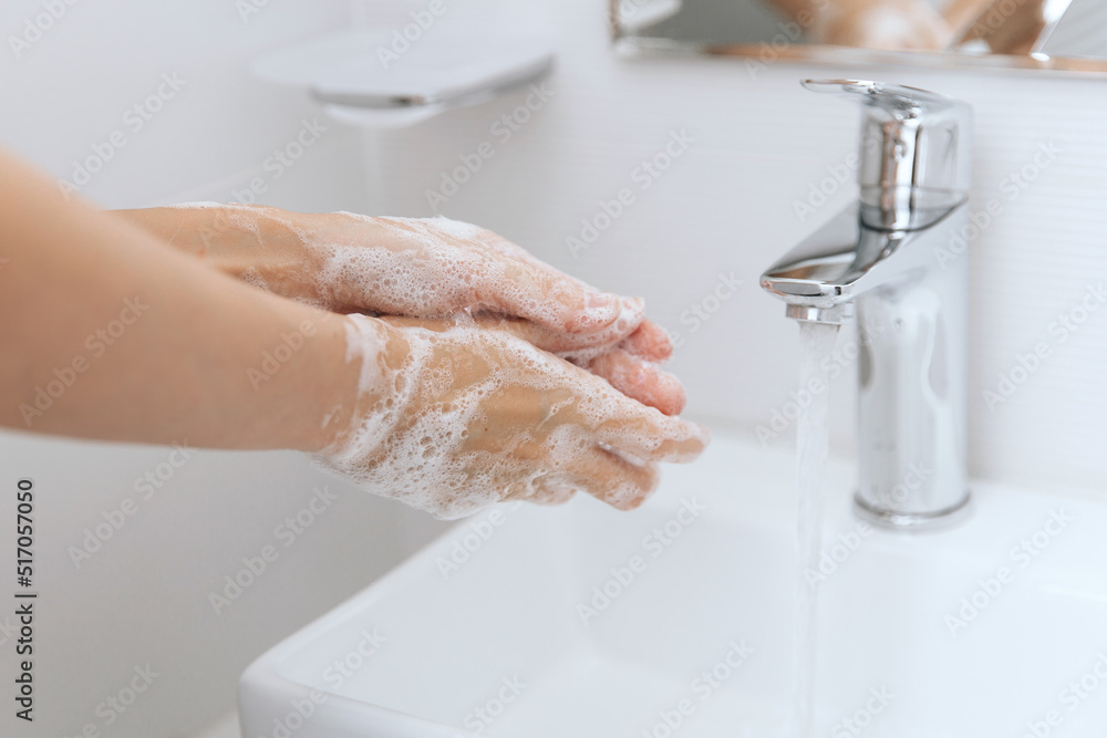 Washing hands under the flowing water tap. Washing hands rubbing with soap for corona virus prevention, hygiene to stop spreading corona virus in or public wash room. Hygiene concept hand detail Washing hands under the flowing water tap. Washing hands rubbing with soap for corona virus prevention, hygiene to stop spreading corona virus in or public wash room. Hygiene concept hand detail