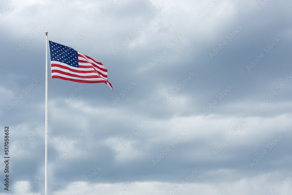 American flag on the gray sky. Cloudy day