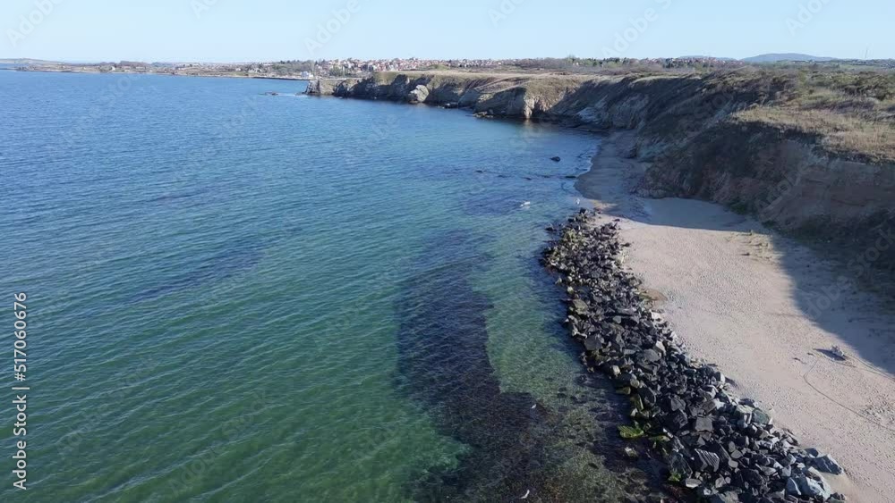 Shore with grass and hotels in the distance surrounded by the Black Sea under a clear sky Shore with grass and hotels in the distance surrounded by the Black Sea under a clear sky