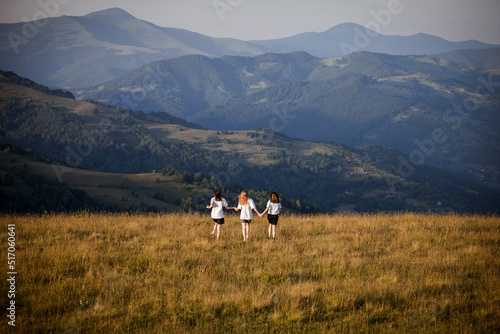 Three Young Girls Running into the Beautiful Mountains © andrii_popovych