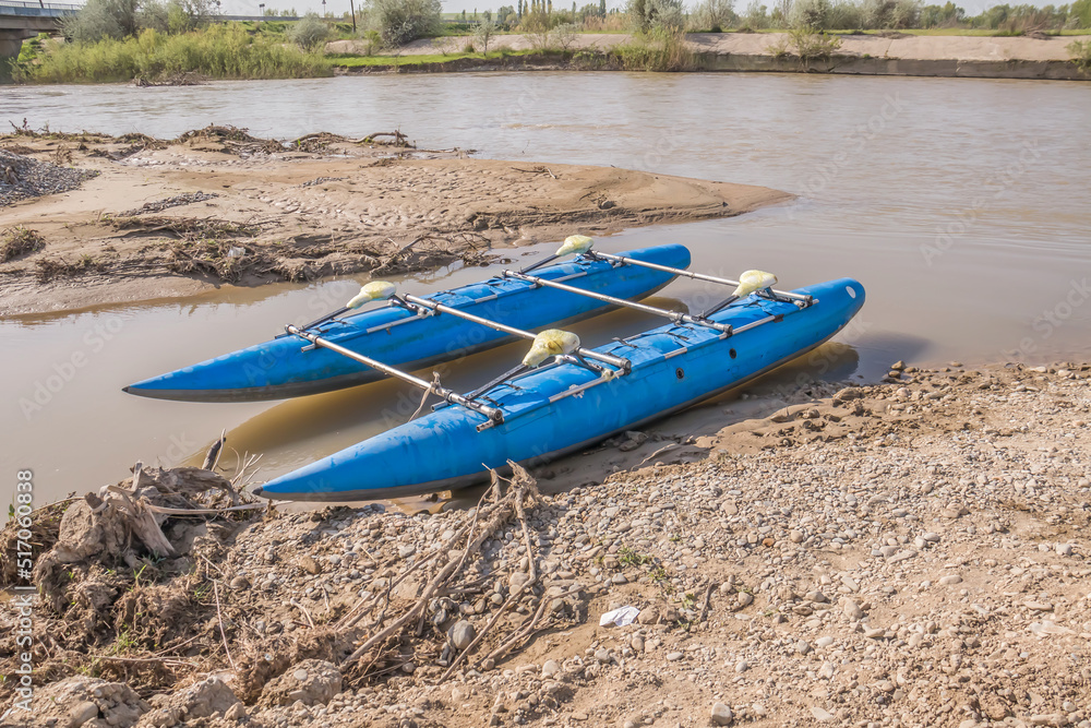 Inflatable catamaran for rafting on the river on the shore in summer Inflatable catamaran for rafting on the river on the shore in summer