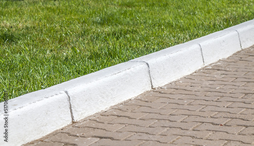 Fotografie Whitewashed concrete curb in the park close-up