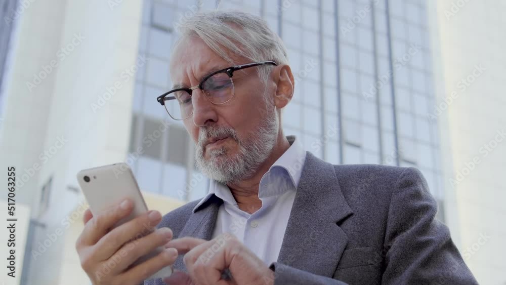 Nervous man unlocking phone and dialing number, calling taxi standing outdoor Nervous man unlocking phone and dialing number, calling taxi standing outdoor