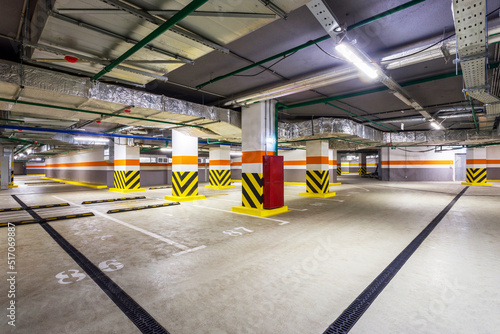 view of new empty underground parking with concrete columns and nobody inside